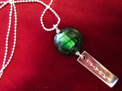 NA012 Green strength: Halsband med grn prla och tag med texten 