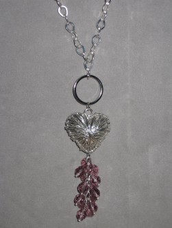 HA093 Ring heart: Långt halsband (ca 70cm) med trasselhjärta och klase med lila facetterade pärlor...Finns att köpa hos Studio Mini SÅLDFör att se en större bild, klicka på denna länk.