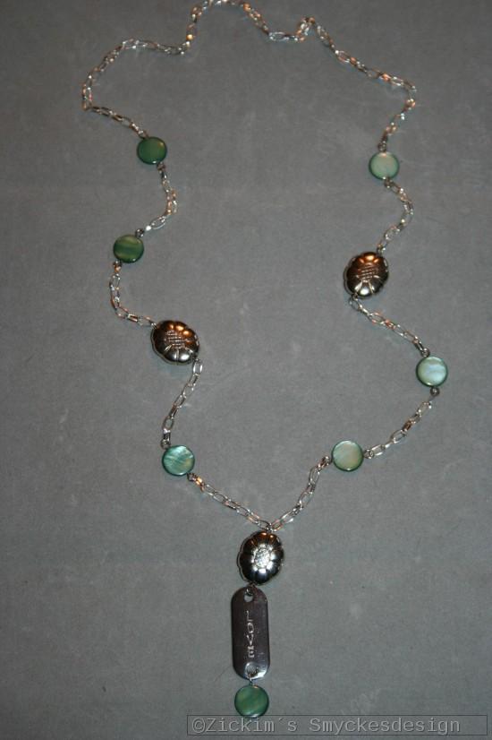 HA160 Green love: Halsband (68 cm) med gröna snäckskalspärlor samt ett stansat hänge med texten 